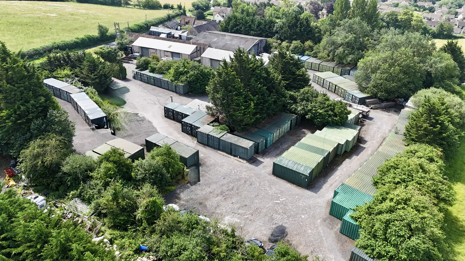 Aerial view of Perry Storage, with the container yard set among trees on the edge of a Bath village
